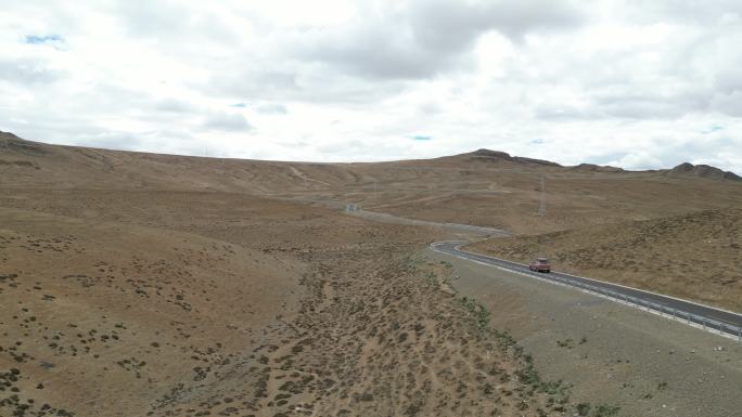 一辆旅居车行驶在米黄色的高原公路