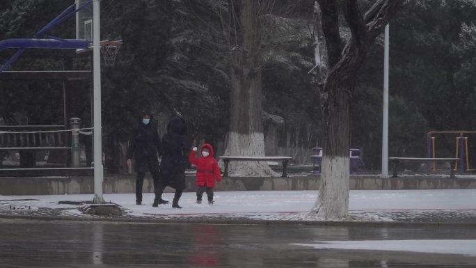 下雪天一家三口父母和孩子打雪仗玩耍