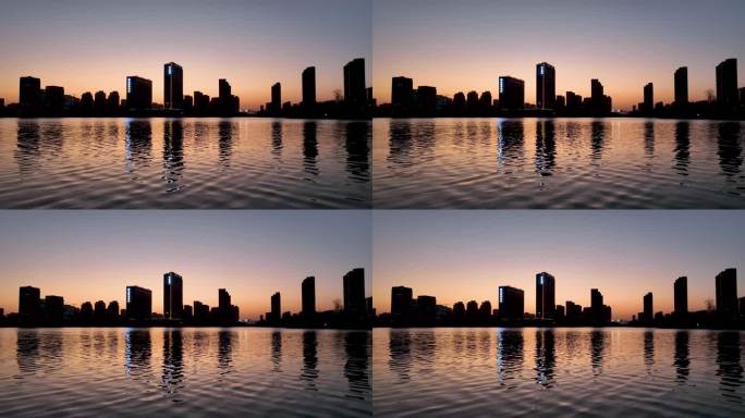 夕阳晚霞中的城市倒映在波光潋滟的湖水中