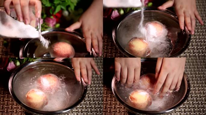 水盆里刷洗桃子去掉桃毛