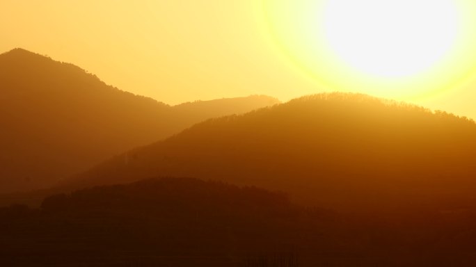 逆光夕阳下晚霞里水库傍边的小山村