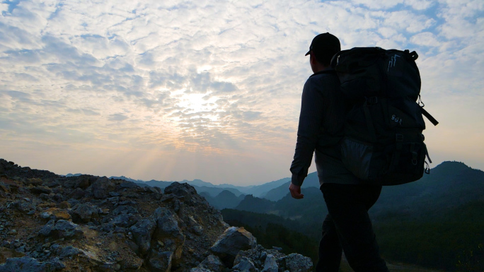 男人背着登山包爬山背影登上山顶攀登山峰