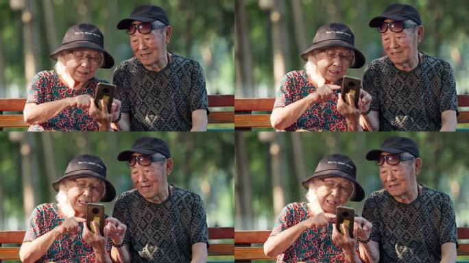 老人幸福的老年夫妇坐在公园长椅看手机聊天