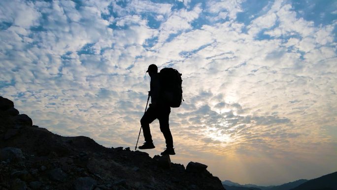 男人登山剪影背包客向山顶出发登山运动爬山
