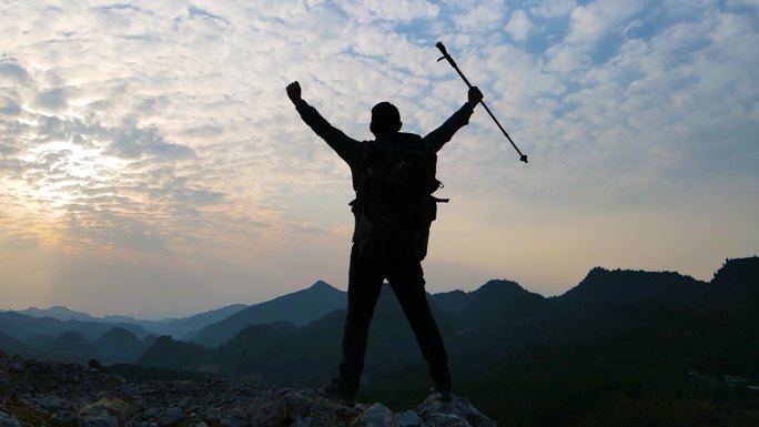 成功登顶男人站在山顶举手欢呼登山攀登顶峰