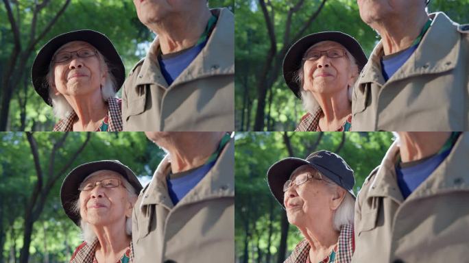 老人面带笑容的老年夫妇在公园里散步
