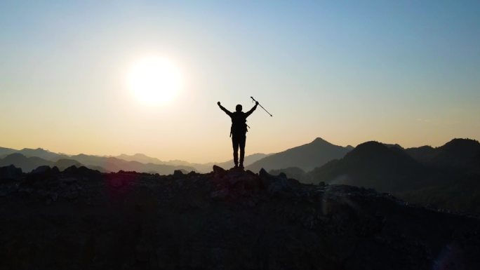 山顶人物逆光剪影成功登顶举手庆祝欢呼眺望