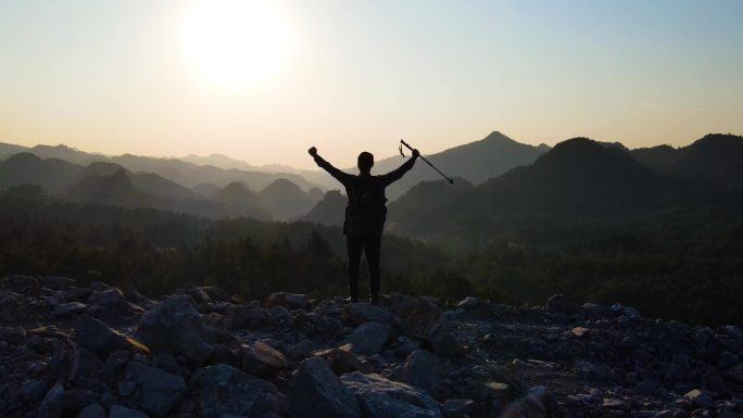 男人成功登上山顶举手欢呼庆祝山顶眺望远方