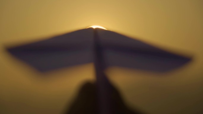 夕阳下的纸飞机剪影