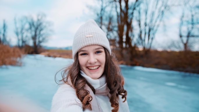 年轻女子在结冰的湖面上自拍的照片