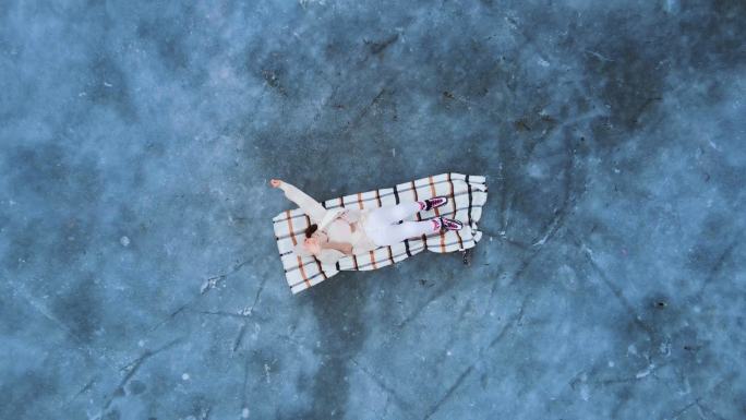 年轻女子躺在结冰的湖面上