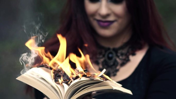 手持燃烧书的哥特式女人