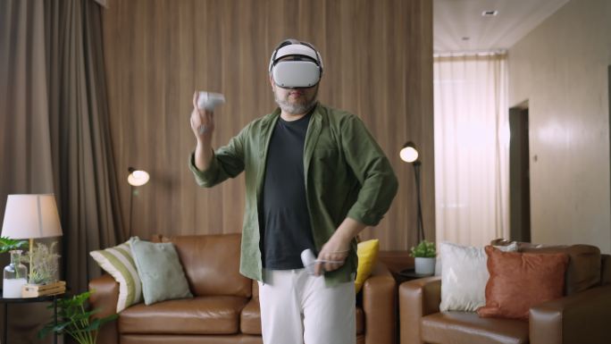 流亡亚洲活跃男性在家客厅享受虚拟增强现实元宇宙电子竞技在线数字世界游戏，休闲放松男性在家玩数字休闲游