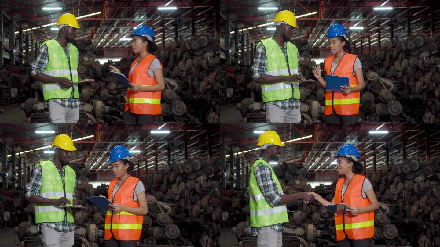 多种族工人在车辆废料场检查零部件后与同事握手