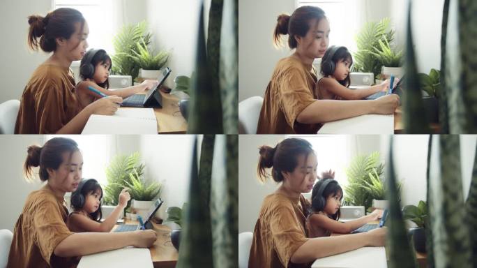 亚洲女儿和母亲一起在家上网课。