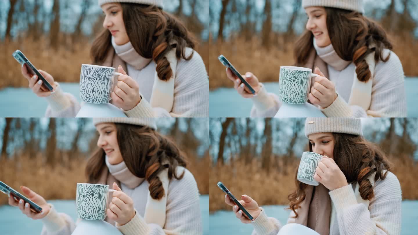 美丽的年轻女子喝咖啡时使用手机
