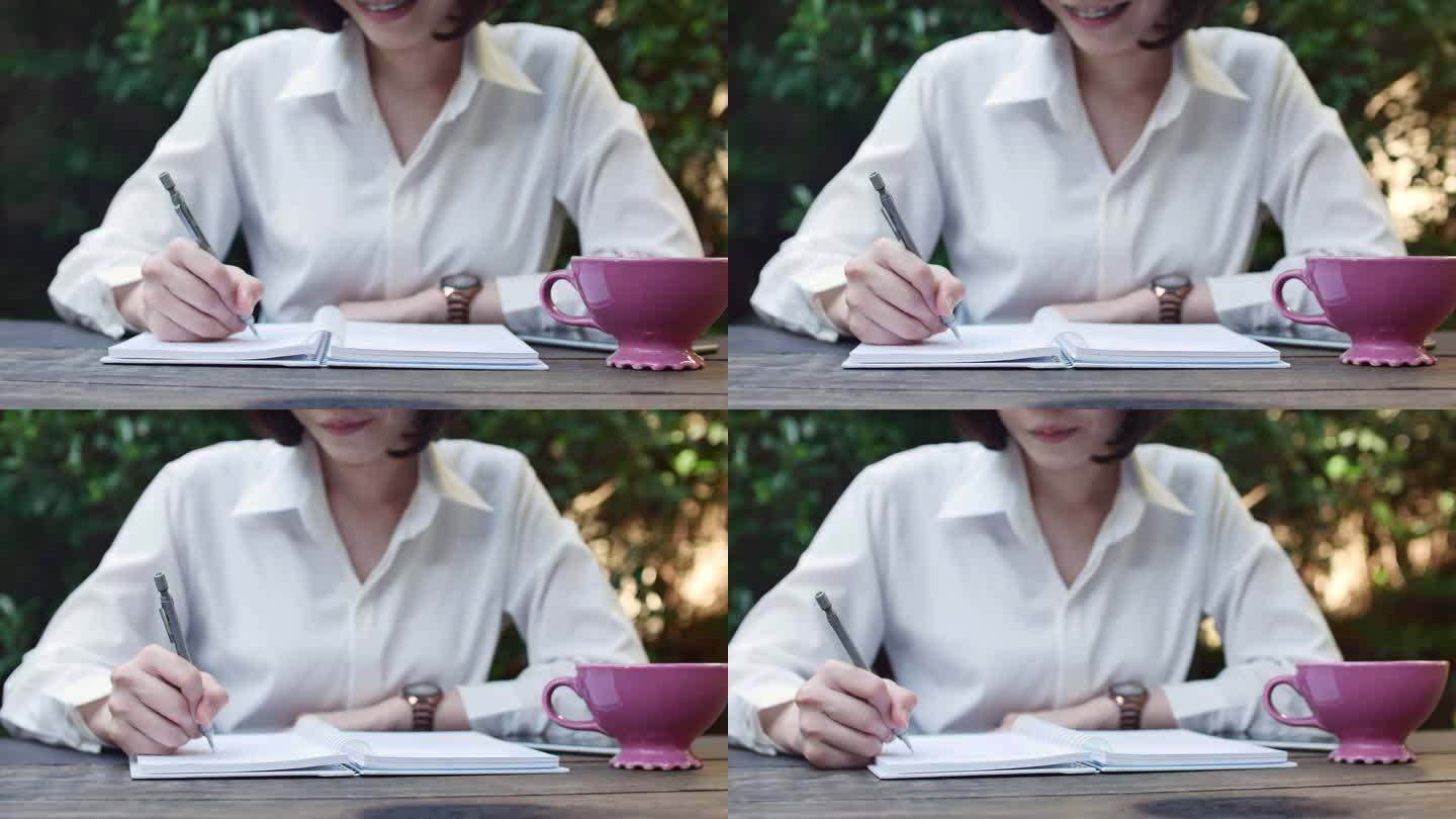 在咖啡馆用纸质书写笔记的女人