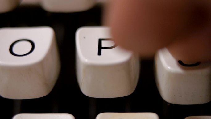 在老式老式打字机上用手指打字字母P。