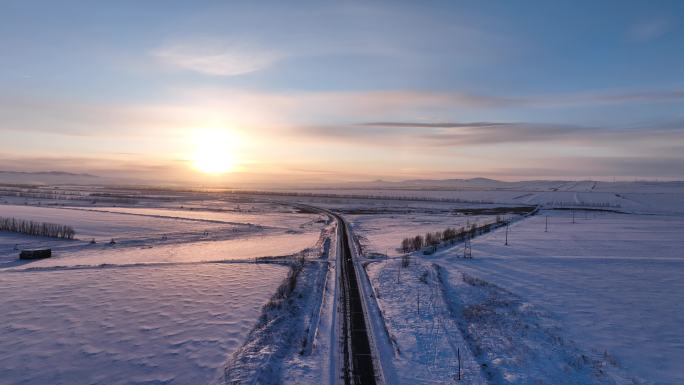 航拍暮色中穿越雪原的公路