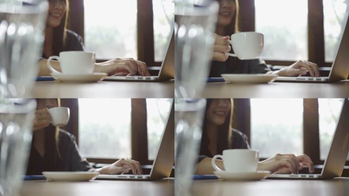 亚洲女人在笔记本电脑上工作，喝咖啡