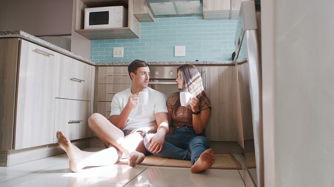 一对年轻夫妇坐在家里厨房地板上的4k视频片段