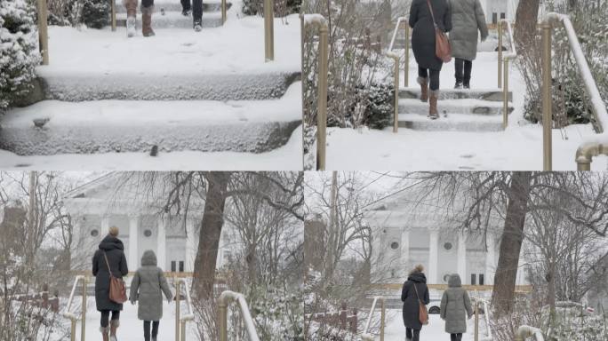 朋友们在小镇上走上白雪覆盖的台阶
