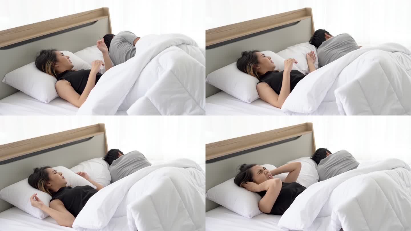 女人用枕头捂住耳朵。