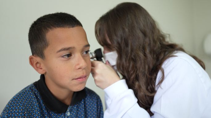 医生用耳镜检查男孩的耳朵