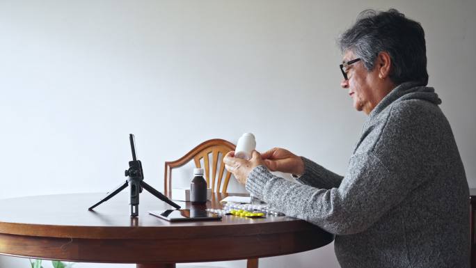 老年妇女通过视频电话与医生谈论她的药物
