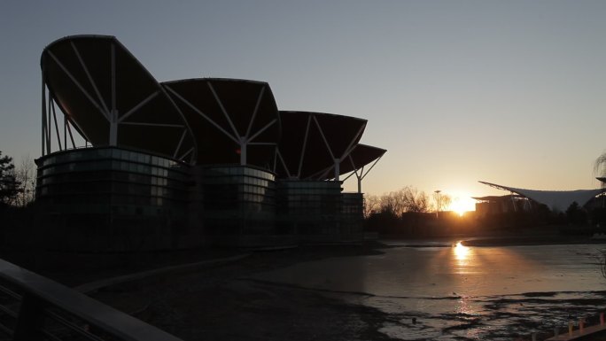 花博会公园夕阳下主体建筑半剪影湖面已结冰