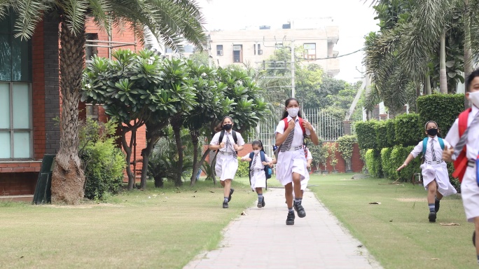 戴着防护面罩的儿童跑步上学