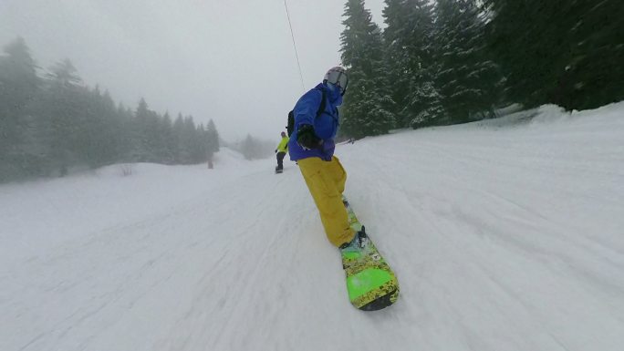 兴奋的男性在山区边远地区骑滑雪板