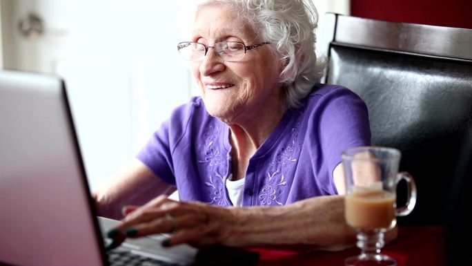 快乐的老年女性使用笔记本电脑
