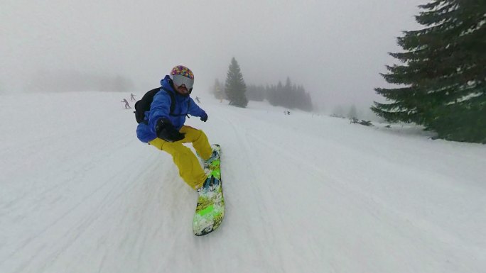 兴奋的男性在山区边远地区骑滑雪板