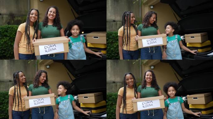 母亲和女儿把卡片盒放进汽车后备箱的肖像