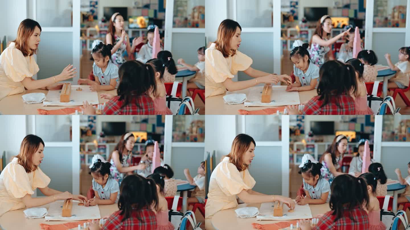 亚洲华人蒙台梭利幼师在课堂上用玩具积木向学生讲解