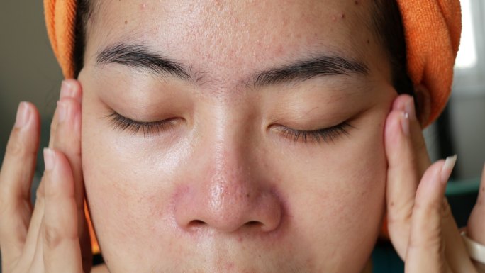 亚洲女性使用面霜或防晒霜化妆的一部分