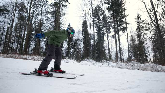 十几岁的男孩在森林里的小滑雪坡上滑雪