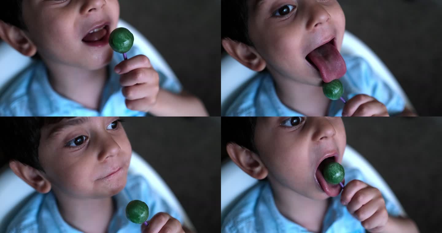 可爱的蹒跚学步的小男孩正在吃棒棒糖。
