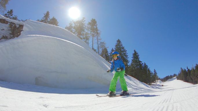 小女孩学滑雪滑雪女孩快速经过冬天雪山森林