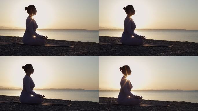 健康的年轻女子坐在瑜伽莲座上，闭着眼睛在海边，日出时在海滩上冥想。