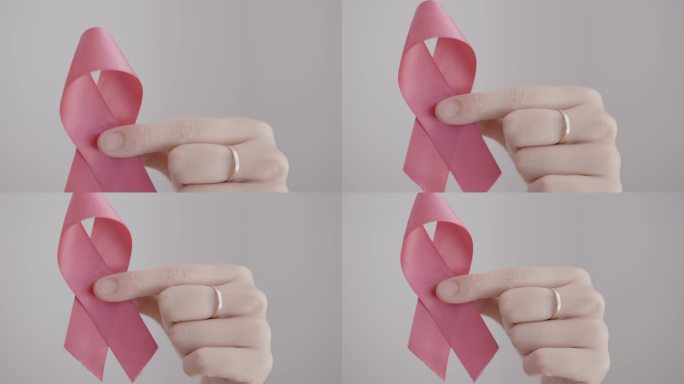 手持粉色丝带、乳腺癌意识和十月粉红日、世界癌症日