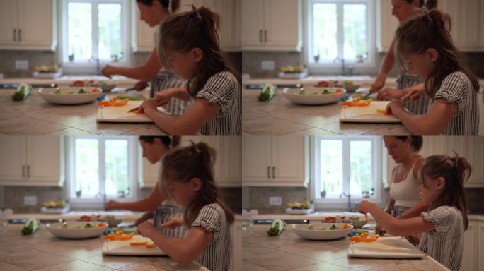 一个年轻的女孩在厨房里帮助她的妈妈。