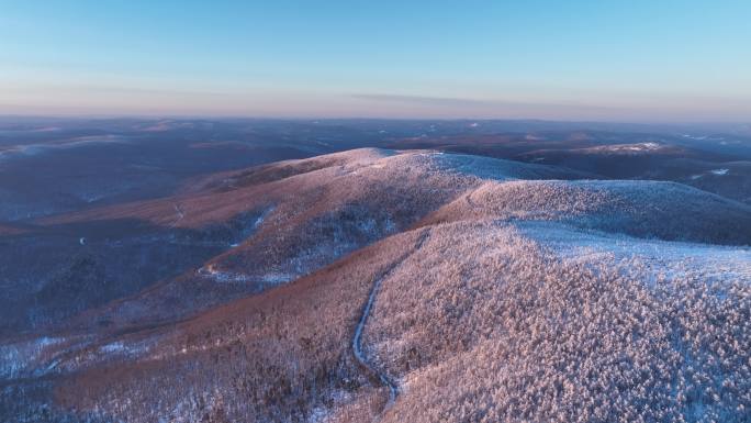 航拍夕阳下的兴安岭雪色山林