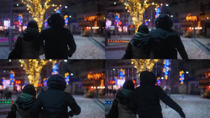 冬天夜里下雪时，年轻的夫妇在城里散步