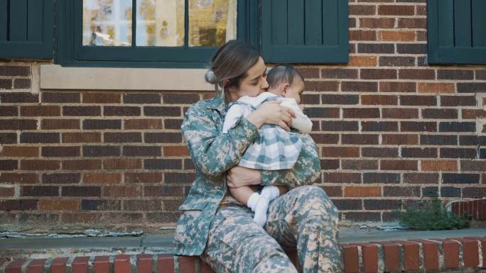 悲伤的女兵害怕离开女婴去执行军事任务