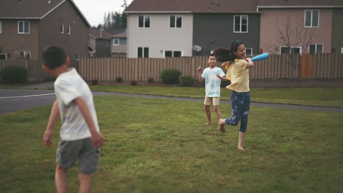 一群孩子在郊区社区公园玩有趣的棒球游戏