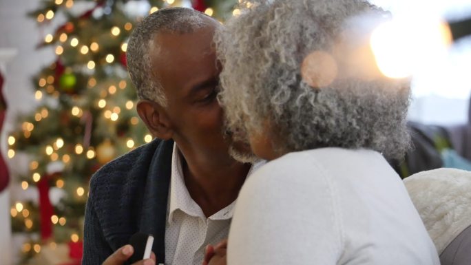 非洲裔美国老夫妇交换圣诞礼物后接吻