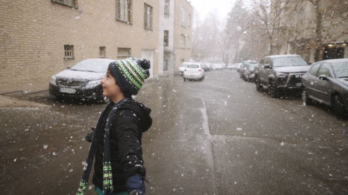 混血男孩在雪地里玩耍，微笑，享受