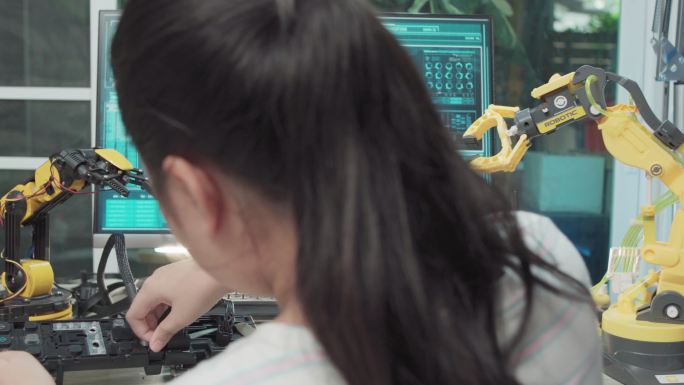 教育主题：女孩学习如何在数字平板电脑上控制机器人手臂，科学工程，教育，技术